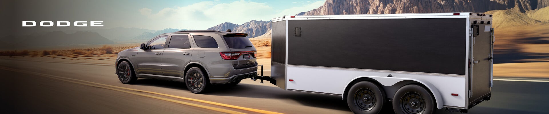 2026 Dodge Durango R/T in Destroyer Gray with Blacktop and Tow N Go packages, rear three-quarter view towing a trailer.