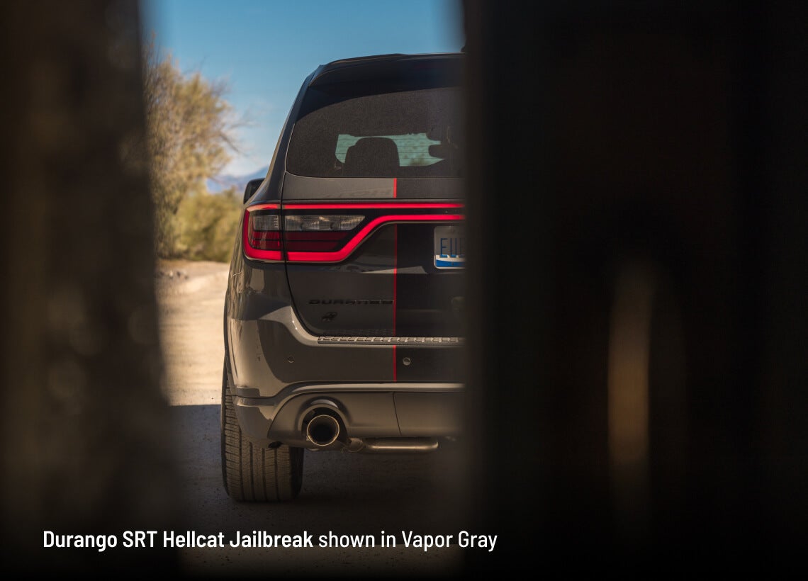 Dodge Durango SRT Hellcat Jailbreak in Vapor Gray, rear view framed between dark foreground panels.