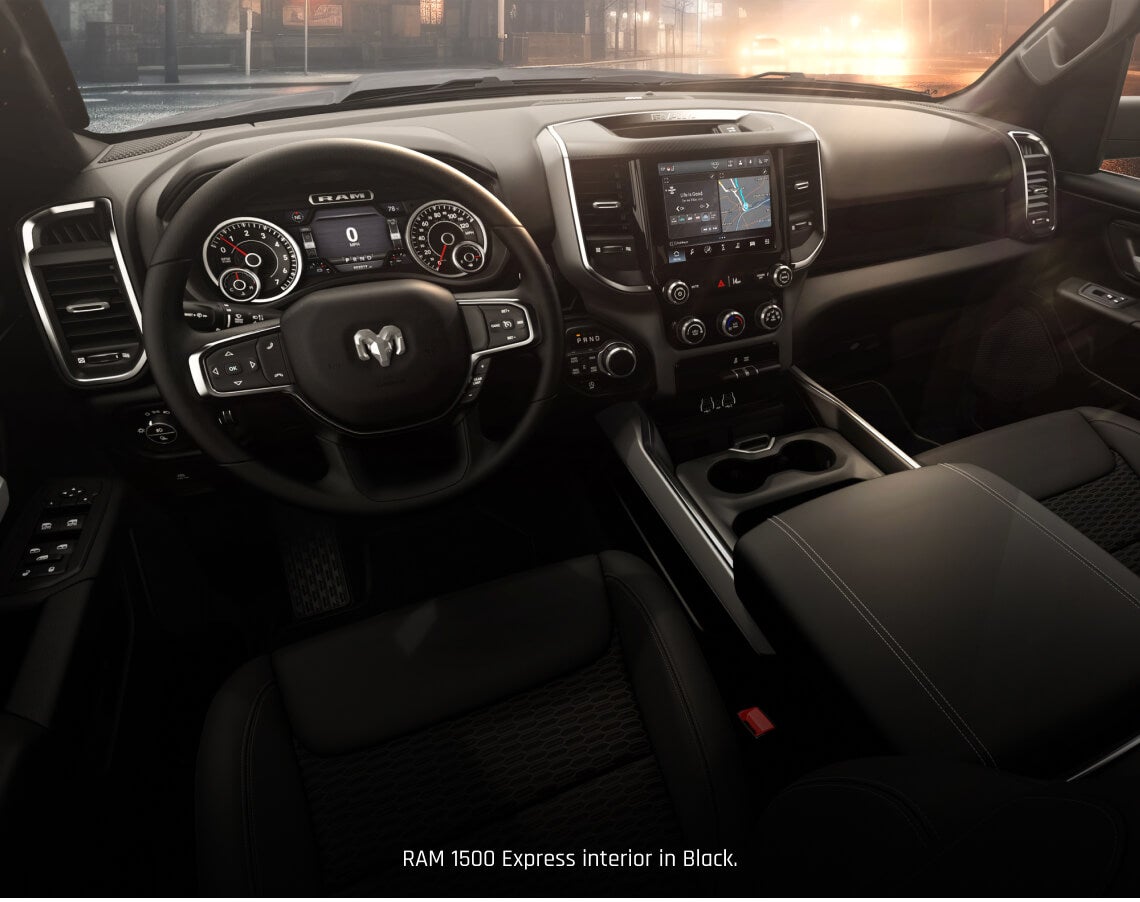 Interior cockpit view of a Ram 1500 Express in Black highlighting the modern steering wheel.