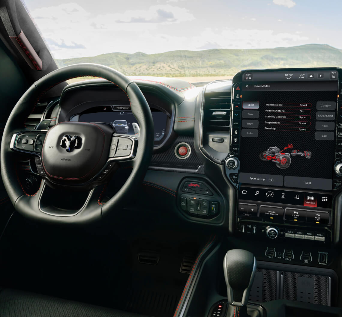 Interior view of a Ram 1500 with black leather and red stitching facing outdoor mountain.