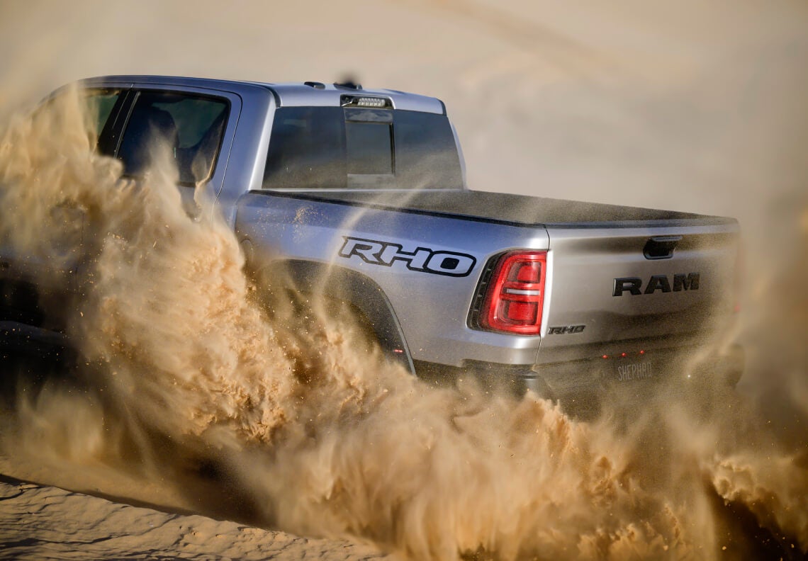 Silver Ram Truck kicking up dirt while off-roading